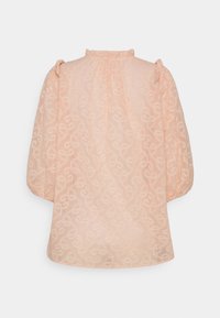 Blusa color pesca con un motivo a spirale testurizzato, scollatura arricciata e maniche a palloncino. Tessuto leggero e trasparente con una vestibilità comoda.