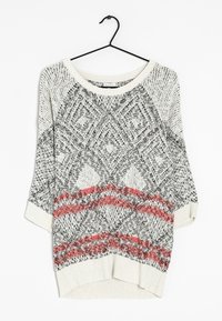 Lekki kremowy sweter z czarno-czerwonymi geometrycznymi wzorami, dekoltem w serek, rękawami do połowy przedramienia i prążkowanym wykończeniem dolnym. Wyraźna tekstura dzianiny.