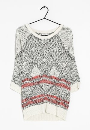 Leichter cremefarbener Pullover mit schwarzen und roten geometrischen Mustern, Rundhalsausschnitt, dreiviertel Ärmeln und geripptem Saum. Die Strickstruktur ist deutlich sichtbar.