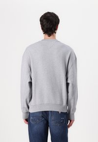 Gray sweatshirt with a relaxed fit, ribbed cuffs and hem, and a crew neck. Made from soft fabric, featuring a smooth texture and minimal detailing.