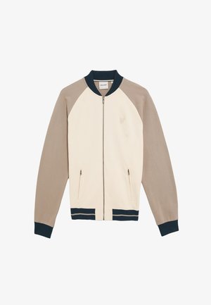 Cremefarvet zip-jakke med beige raglanærmer. Har marineblå ribbede manchetter og kant, to lommer med lynlås samt en diskret logo-detalje.