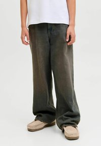 Široke, tamnozelene traperice s izblijedjelom teksturom, s klasičnim dizajnom od pet džepova i opuštenim krojem. Uparene sa svijetlim mokasinkama.