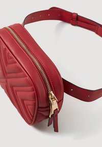 Sac bandoulière en cuir rouge avec un design matelassé, une fermeture éclair dorée et une sangle ajustable. Présente une forme arrondie et une doublure intérieure noire.