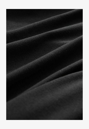Juodas audinys, turintis minkštus, tekstūrinius bangas su lengva blizgesiu, demonstruojantis lygų paviršių ir subtilius šviesos skirtumus.