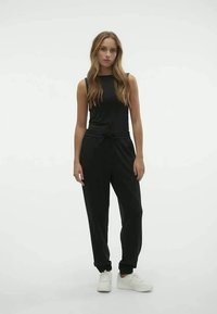 Black sleeveless top paired with black jogger pants, both made of soft fabric. The joggers feature an adjustable waistband and cuffed ankles.