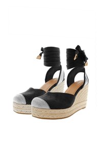 Černé semišové wedge boty s pletenou jutovou podrážkou, černými kotníkovými popruhy a čtvercovými látkovými špičkami. Otevřený zadní design s zaobleným tvarem.