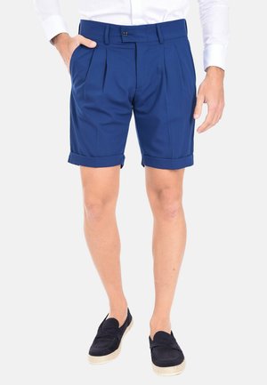 Pantaloni corti plissettati blu navy con risvolti, realizzati in tessuto leggero. Presentano una chiusura frontale con bottone e tasche laterali.