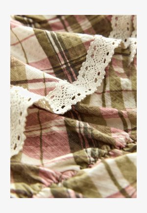 Kockovaná látka v ružovej, hnedej a smotanovej farbe s čipkovaným lemovaním. Má jemnú textúru a zbiehajúci sa detail pozdĺž okraja.
