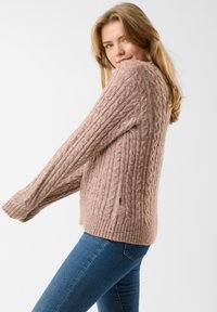 Sweter w warkocze w miękkiej, beżowej wełnie, z teksturowanym wzorem, długimi rękawami oraz ściągaczami w mankietach i u dołu.