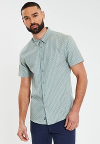 Kurzarm-Hemd mit Knopfleiste in Hellgrün und mit einem gemusterten Design. Mit Kragen, regular fit und einem Etikett am unteren Saum.