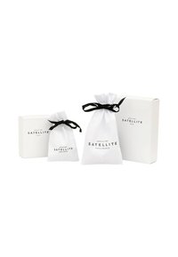 L'emballage cadeau blanc comprend deux sacs à cordon et une boîte. Les sacs ont des liens en ruban noir ; la boîte est simple avec un imprim�é minimal.