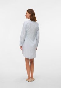 Lichtblauw-wit gestreepte overhemdjurk met lange mouwen, een kraag en een licht gebogen zoom. Gemaakt van een gladde stof.