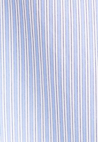 Motif de rayures verticales en bleu clair, bleu foncé et blanc sur une surface en tissu, espacées régulièrement et aux couleurs alternées.