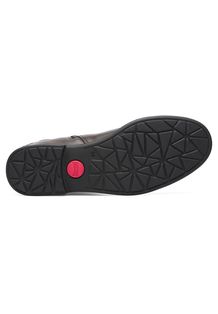 Suola di scarpa in pelle marrone con una suola in gomma nera testurizzata, che presenta un logo circolare rosa e un motivo di triangoli per la trazione.