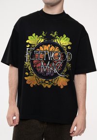 Black cotton T-shirt featuring a colorful floral graphic with the text "Fleetwood Mac," in a relaxed fit with short sleeves.