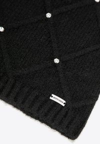 Sciarpa nera lavorata a maglia con un motivo testurizzato, decorata con dettagli in cristallo. Presenta un bordo a coste e un piccolo etichetta del marchio.