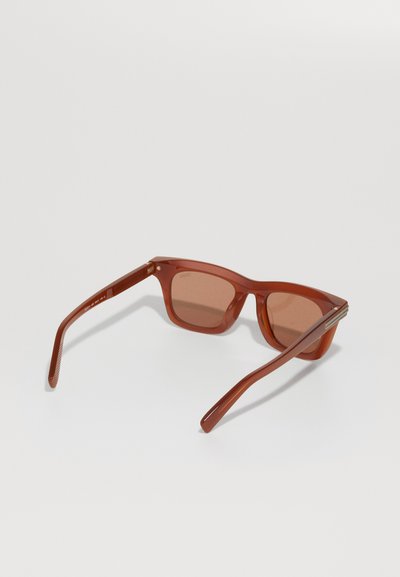 Brown rectangular sunglasses with tinted lenses, plastic frame, thick temples, and a subtle silver accent near the hinges.