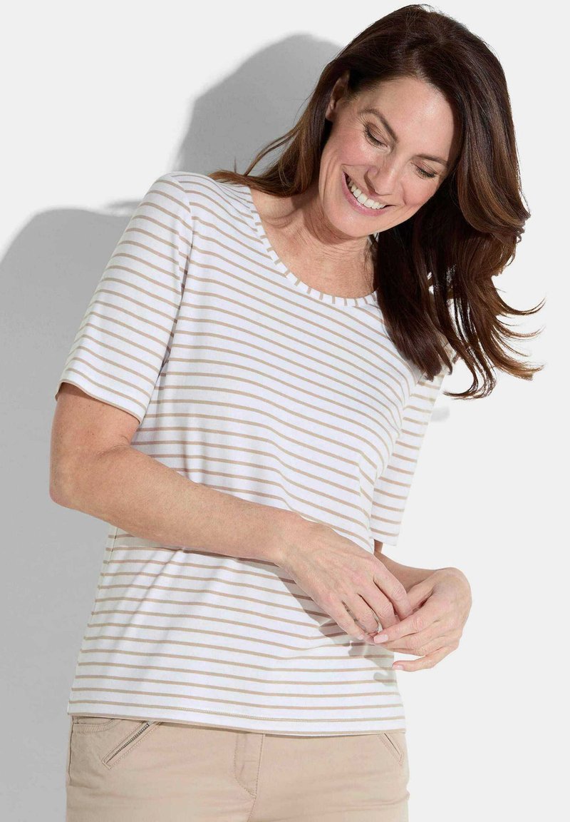 Weißes T-Shirt mit hellbeigen horizontalen Streifen, Rundhalsausschnitt, kurzen Ärmeln und weicher Textur, kombiniert mit hellbeigen Hosen.