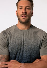 Camiseta deportiva de manga corta en gris con un patrón en degradado que transiciona a azul oscuro; fabricada con un tejido suave y que absorbe la humedad.