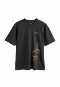 T-shirt noir à manches courtes et col rond avec un texte orange "Shinjuku Studios" et un graphisme détaillé d'un serpent enroulé sur le bas avant droit.