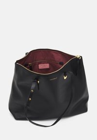 Zwarte leren totebag met een gestructureerd oppervlak, gouden hardware accenten en een bordeauxrode stoffen binnenkant. Voorzien van een ritssluiting en een binnenlabel.