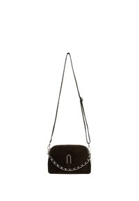 Sac bandoulière en suède noir avec détail chaîne argentée et sangle ajustable suspendu sur un fond blanc.