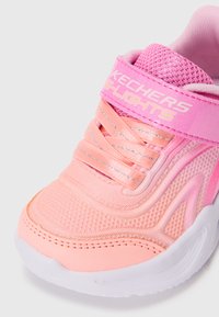 Skechers tenisice sa svjetlima u ružičastoj boji, s teksturiranim mrežastim gornjim dijelom, elastičnim vezicama i čičak trakama s logom. Bijela potplata.