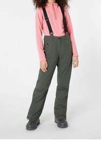 Pantaloni da sci verdi con bretelle nere regolabili, abbinati a una maglietta a maniche lunghe rosa chiaro; presentano tasche laterali e un design a gamba dritta.