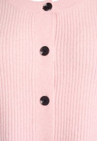 Gaiši rozā ribotais kardigans ar apaļu kakla izgriezumu un četriem melniem pogām priekšpusē, izgatavots no maigas tekstūras.