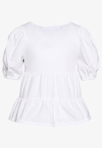 Bílá bavlněná blůza s nafouknutými rukávy, kulatým výstřihem a volánkovým lemem. Texturovaná látka dodává měkký a lehký vzhled.