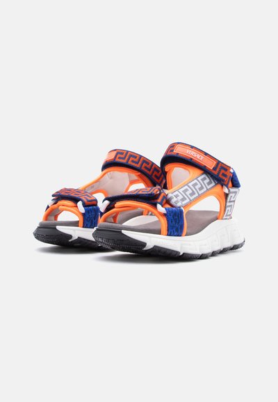 Αθλητικά σανδάλια με παχιές λευκές σόλες, με πορτοκαλί, μπλε και γκρι λουράκια με γεωμετρικά σχέδια και ορατό λογότυπο Versace στο λουράκι του αστραγάλου.