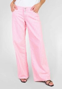 Roze gestreepte wijde broek met twee voorzakken, twee knoopsluitingen en een gladde textuur. De stof heeft witte verticale strepen.