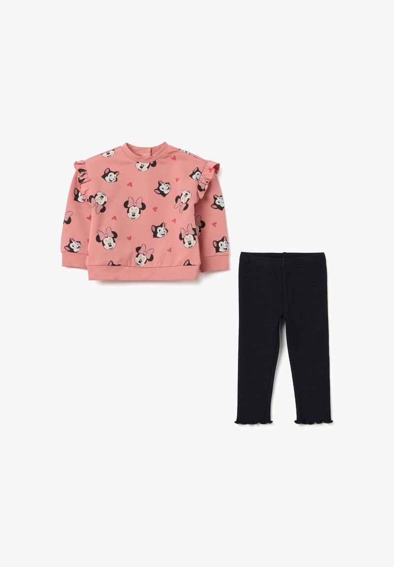 Roze sweatshirt met ruches aan de mouwen, voorzien van afdrukken van cartoonpersonages en harten. Gemaakt in combinatie met marineblauwe leggings met gegolfde zoom.