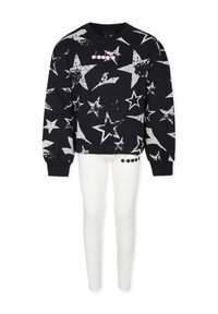 Felpa nera con stampe di stelle bianche e un logo rosa, abbinata a leggings bianchi aderenti. Entrambi i capi sono realizzati in morbido tessuto.