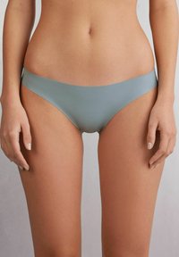Korte bikini in een zachte, gemuteerde blauwe stof. Kenmerkt zich door een naadloos ontwerp met een low-rise taille en een gladde textuur, geschikt voor dagelijks gebruik.