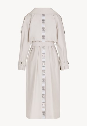 Beżowy długi płaszcz trencz z paskiem, paskami przy mankietach oraz pionowym nadrukiem w paski z napisem "BIZUU" na środku pleców.