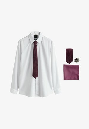 Weißes langärmeliges Hemd mit umgeschlagenem Kragen, dunkelviolette gemusterte Krawatte, passendes Einstecktuch und runde Krawattennadel auf weißem Hintergrund.
