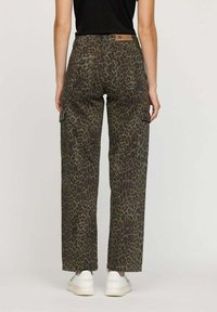 Pantalons cargo de couleur vert foncé avec un motif léopard. Conçus avec une coupe droite, ils possèdent des poches avant et latérales, ainsi qu'une étiquette en cuir à la taille.