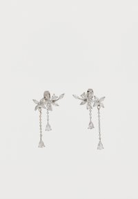 Ezüst virágmintás fülbevalók tiszta csepp alakú kristályokkal és finom láncokkal, amelyek mindegyik fülbevalóból lógnak, fehér háttér előtt.