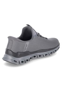 Grauer Sportschuh mit atmungsaktivem Mesh-Obermaterial, dicker, gepolsterter Sohle und strukturiertem Muster, mit einer Schlaufe zum Hereinziehen an der Rückseite.