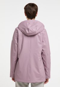 Giacca impermeabile viola chiaro con cappuccio, caratterizzata da una texture liscia, cuciture verticali e chiusure a scatto ai polsi.