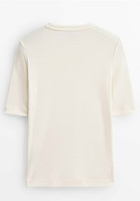 T-paita lyhyillä hihoilla, kermanvärinen, pehmeästä kankaasta valmistettu, jossa on perinteinen pyöreä kaula-aukko ja rento malli ilman näkyviä etikettejä tai logoja.