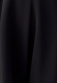 Črna tkanina z gladko, matirano teksturo, s subtilnim drapanjem in pregibi. Brez vzorcev ali vidnih kovinskih delov.