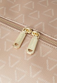 Φακός ροζ ψεύτικου δέρματος με επαναλαμβανόμενο μοτίβο λογοτύπου, χρυσό φερμουάρ με διπλές λαβές και υφή στην επιφάνεια.