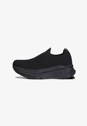 Černá atletická teniska typu slip-on s texturovaným pleteným svrchem a silnou polstrovanou podrážkou, zobrazena z boku na bílém pozadí.
