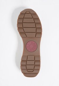 Podeszwa buta z teksturowanej, brązowej gumy, z poziomymi i pionowymi rowkami oraz okrągłym logo na środku.