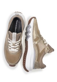 Sneaker in rete dorato e pelle con lacci bianchi, lati texturizzati, un'etichetta per il pull e una suola intermedia bianca spessa e frastagliata; suola in gomma marrone.