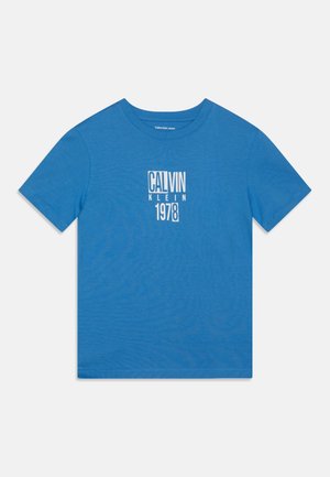 T-shirt di cotone blu con collo rotondo, maniche corte e stampa grafica con la scritta "CALVIN KLEIN 1978" in bianco centrata sul davanti.