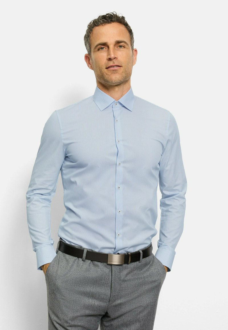 Helles blaues Langarmhemd mit einem subtilen Streifenmuster, Button-down-Kragen und Knopfverschlüssen. Getragen mit grauen maßgeschneiderten Hosen.