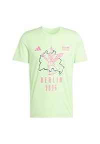 Camiseta de manga corta verde claro con un gráfico de una figura alada, el contorno de la ciudad de Berlín y el texto "BMW BERLIN 2025" en rosa.